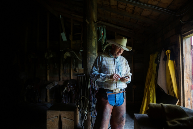 Rancher with cell phone in barn